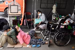 Cảnh bệnh nhân vật vờ chờ đợi ngoài bệnh viện dã chiến ở Jarkatar, Indonesia.