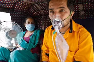 Một bệnh nhân đeo máy thở chờ đợi để được nhập viện ở Ấn Độ.