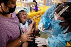 Y tá tiêm vaccine cho một em bé ở Philippines.