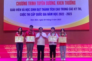 Ông Vừ A Bằng (đứng giữa) trao Bằng khen của UBND tỉnh Điện Biên cho 4 học sinh có thành tích xuất sắc.