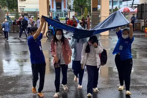 Thí sinh Tiền Giang đến điểm thi trong cơn mưa.