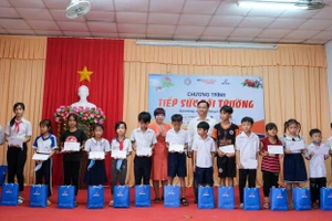 Nhà báo Dương Thanh Hương - Phó Tổng biên tập Báo Giáo dục và Thời đại cùng ông Nguyễn Văn Hiền - Phó Giám đốc Sở GD&ĐT tỉnh Hậu Giang trao quà, học bổng cho học sinh.