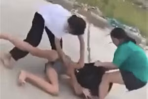 Em Y.N. bị bạn đánh trên bờ đê (Ảnh cắt từ clip).