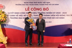 Phó Thống đốc Phạm Tiến Dũng trao Quyết định công nhận Hiệu trưởng và tặng hoa chúc mừng.