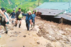 Các thầy cô Trường tiểu học Nhi Sơn và bà con tìm cách vào nhà lấy giấy tờ cho giáo viên