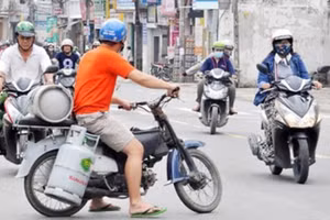 Hình ảnh nhân viên giao gas mặc nhiên “cõng” nhiều bình gas di chuyển trên đường phố đông đúc vẫn thường xuyên xuất hiện.