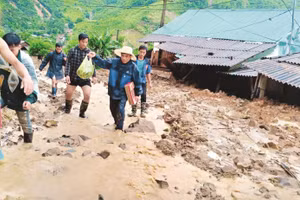 Các thầy cô Trường tiểu học Nhi Sơn và bà con tìm cách vào nhà lấy giấy tờ cho giáo viên