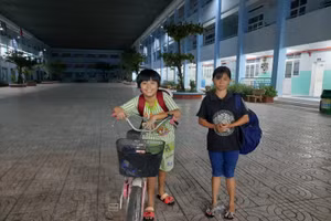 Cô bé Nguyễn Hồ Anh Thư, 14 tuổi, cùng bạn Phan Anh Kiệt học lớp 5, đều dặn mỗi tuần 3 buổi đạp xe đến trường học phổ cập ban đêm. Ảnh: TG