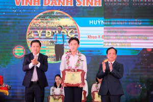 Ông Lương Nguyễn Minh Triết – Phó Bí thư Thường trực Thành ủy Đà Nẵng (bìa trái) và PGS.TS Nguyễn Ngọc Vũ – Giám đốc Đại học Đà Nẵng tặng hoa và bảng vinh danh cho các Thủ khoa Đại học Đà Nẵng năm 2020.  