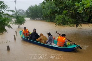 Di chuyển người dân ra khỏi khu vực ngập lũ tại huyện Cam Lộ (Quảng Trị). Ảnh: Thanh Thủy/TTXVN.