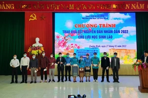 Tiến sĩ Võ Khắc Sơn - Phó Hiệu trưởng Trường Đại học Quảng Bình trao quà Tết cho lưu học sinh Lào.