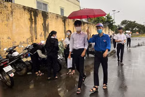 Tình nguyện viên tại Kon Tum hỗ trợ che mưa cho thí sinh vào điểm thi.