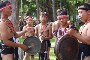 Anh Đinh A Lênh (bên trái) hướng dẫn các em nhỏ đánh chiêng.