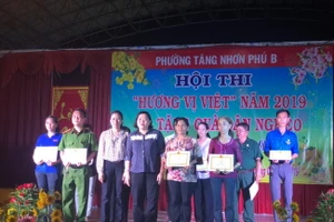 Bà Hoàng Thị Minh Ngọc – Quận Ủy viên, Bí thư Đảng ủy, Chủ tịch HĐND, Trưởng Ban giám khảo ( đứng thứ 3 hàng đầu từ trái qua) tặng giấy khen cho các thí sinh đạt giải phần thi ẩm thực và trang trí Hoa Mai - Hoa Đào.