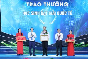 Bí thư tỉnh ủy Nghệ An ông Thái Thanh Quý và Chủ tịch UBND tỉnh ông Nguyễn Đức Trung tặng bằng khen cho em Mai Văn Đức đạt Huy chương Bạc Olympic Hóa học quốc tế. Ảnh: Hồ Lài
