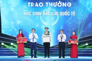 Bí thư tỉnh ủy Nghệ An ông Thái Thanh Quý và Chủ tịch UBND tỉnh ông Nguyễn Đức Trung tặng bằng khen cho em Mai Văn Đức đạt Huy chương Bạc Olympic Hóa học quốc tế. Ảnh: Hồ Lài