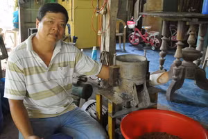 Thầy Chúng bên máy nén viên thức ăn tự chế tạo.