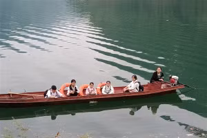 Cô Quách Thị Bích Nụ hàng ngày đưa đón các em qua sông đi học. Ảnh: TG