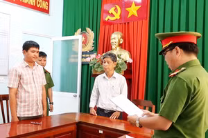 Cơ quan Công an tống đạt các Quyết định và Lệnh bắt tạm giam đối với bị can Nguyễn Thanh Phong (áo sọc). (Ảnh: Tiến Tầm)