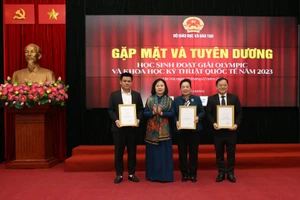 Thứ trưởng Bộ Giáo dục và Đào tạo Ngô Thị Minh trao bằng khen Lê Đình Lực (trái) - Ảnh: NVCC.