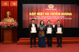 Thứ trưởng Bộ Giáo dục và Đào tạo Ngô Thị Minh trao bằng khen Lê Đình Lực (trái) - Ảnh: NVCC.