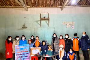 Cô Hiệu trưởng Nguyễn Minh Thu và học sinh, giáo viên nhà trường trao quà ủng hộ gia đình có hoàn cảnh khó khăn. Ảnh: NTCC.