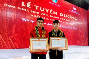 Đinh Lâm Hùng (phải) chụp ảnh kỷ niệm trong Lễ tuyên dương học sinh, sinh viên, thanh niên DTTS xuất sắc, tiêu biểu năm 2022. Ảnh: NVCC.