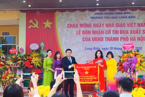 Đồng chí Phạm Bạch Đằng – Chủ nhiệm UBKT Quận ủy Long Biên trao Cờ thi đua cho đại diện nhà trường.