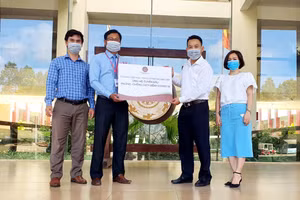 Đại diện Báo GD&TĐ tại Miền Trung - Tây Nguyên đón nhận món quà Trường TH, THCS và THPT Hoàng Việt hỗ trợ các lực lượng chống dịch Covid-19 của tỉnh Hà Tĩnh. 