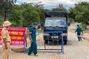 Lực lược chức năng kiểm tra thông tin, phun khử khuẩn các phương tiện chở nhu yếu phẩm hỗ trợ bà con trong khu vực phong tỏa của xã Cư Pui, huyện Krông Bông (ảnh: Thành Tâm).