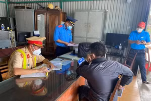 Lực lượng chức năng lập biên bản xử phạt vi phạm hành chính đối với xe khách Khang Phát.