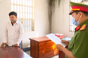 Đối tượng Lê Thanh Vân (áo trắng) nghe đọc lệnh khởi tố, bắt tạm giam.