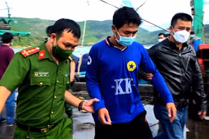 Trần Văn Tài (mặc áo xanh, ở giữa) được đưa về cơ quan điều tra.