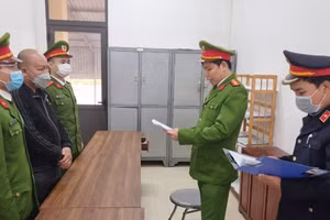 Cơ quan chức năng thi hành các biện pháp tố tụng đối với Phùng Xuân Phong (áo đen ở giữa).