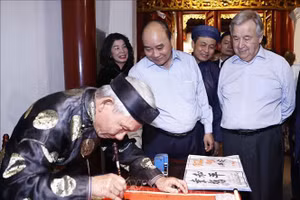 Chủ tịch nước Nguyễn Xuân Phúc và Tổng Thư ký Liên Hợp Quốc António Guterres xem nhà thư pháp viết chữ tại đền Ngọc Sơn. Ảnh: Thống Nhất/TTXVN