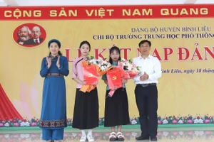 Bí thư Huyện ủy Bình Liêu và Hiệu trưởng Trường THPT Bình Liêu trao quyết định, tặng hoa chúc mừng 2 đảng viên mới.