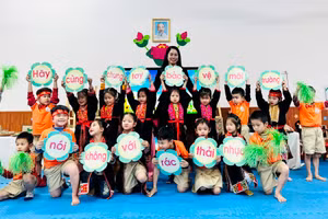 Cô giáo Phạm Minh Huệ, Hiệu trưởng Trường Mầm non Hạ Long cùng các em học sinh cầm khẩu hiệu bảo vệ môi trường.