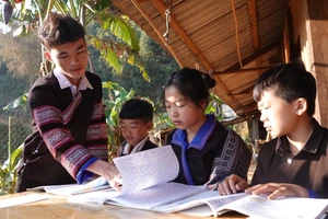 Sùng A Chua (ngoài cùng bên trái) đang hướng dẫn các em nhỏ ôn bài trong đợt nghỉ Tết nguyên đán Giáp Thìn.