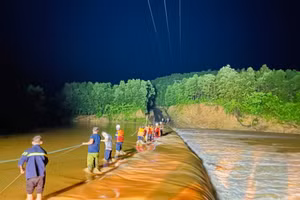 Các chiến sĩ dàn hàng giữa cầu tràn để đưa 3 thanh niên gặp nạn vào nơi an toàn (Ảnh: Phòng Cảnh sát PCCC và CNCH)