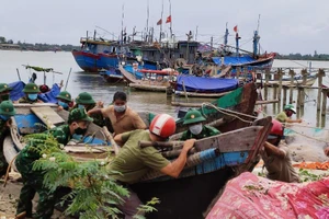 Lực lượng biên phòng hỗ trợ bà con ngư dân đưa tàu thuyền vào nơi neo đậu tránh trú bão.