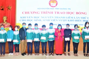 Đại diện Hội khuyến học tỉnh Quảng Trị trao các suất học bổng cho học sinh, sinh viên có hoàn cảnh khó khăn. Ảnh: SH