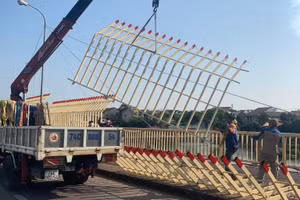 Các công nhân tiến hành tháo dỡ dàn lan can trang trí cầu Đại An giữa trưa nắng.