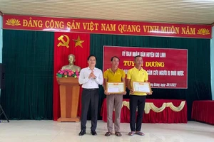 Ông Dương Đức Hạnh - Phó Chủ tịch UBND huyện Gio Linh tặng giấy khen cho 2 ngư dân tại lễ tuyên dương.