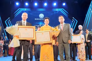 PGS.TS Nguyễn Văn Trào, Phó Hiệu trưởng Trường ĐHSP Hà Nội tặng hoa chúc mừng GS.TS Trần Đăng Xuyền (trái ảnh) và đại diện gia đình cố GS.TS Trương Hữu Quýnh (giữa ảnh).