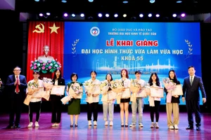 PGS.TS Bùi Huy Nhượng - Phó Hiệu trưởng, PGS.TS Phạm Quang - Trưởng khoa ĐH Tại chức trao giấy khen và tặng hoa cho các tân sinh viên. 