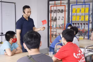 Thầy giáo trẻ Phạm Việt Dũng và học sinh tại Phenikaa School.