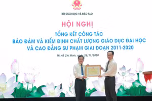 Thứ trưởng Bộ GD&ĐT Hoàng Minh Sơn trao Bằng khen của Bộ trưởng Bộ GD&ĐT cho Cục trưởng Cục Quản lý chất lượng Mai Văn Trinh.