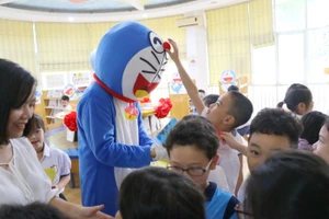 Em nhỏ nào cũng thích thú khi được vây quanh và chạm vào chú mèo máy mình đã yêu thích trong truyện tranh trong lễ kỷ niệm 10 năm thành lập thư viện Fujiko F. Fujio.