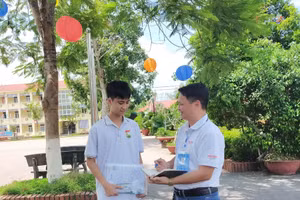 Thí sinh Vũ Anh Tuấn (Điểm thi trường THPT Thanh Sơn, huyện Thanh Sơn) trao đổi với Nhà báo Minh Sơn (bên phải) trước khi bước vào môn thi Ngoại ngữ chiều 28/6.