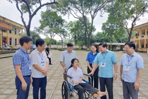 Giám đốc Sở GD&ĐT tỉnh Phú Thọ Nguyễn Văn Mạnh (thứ 2 từ phải sang) động viên thí sinh Nguyễn Phương Thảo bị gãy chân, sau khi kết thúc môn thi Ngữ văn tại điểm thi trường THPT Phong Châu, huyện Lâm Thao.